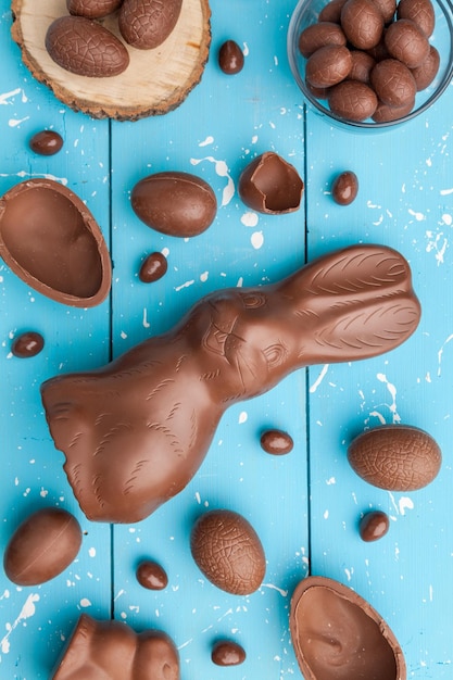 Schokoladen-Osterhaseneier und Süßigkeiten auf rustikalem Hintergrund