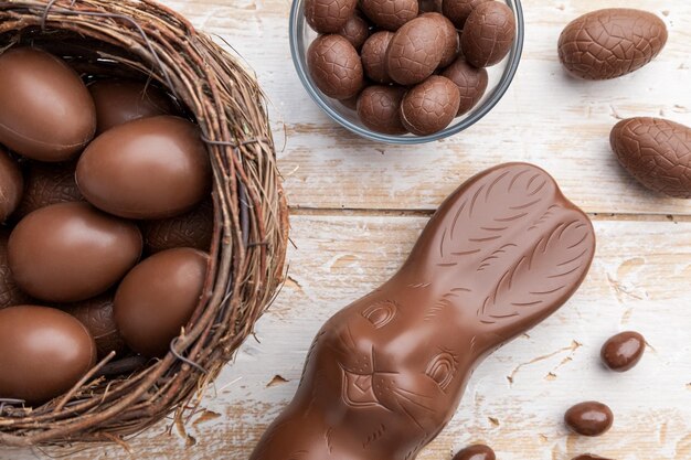 Schokoladen-Osterhaseneier und Süßigkeiten auf rustikalem Hintergrund