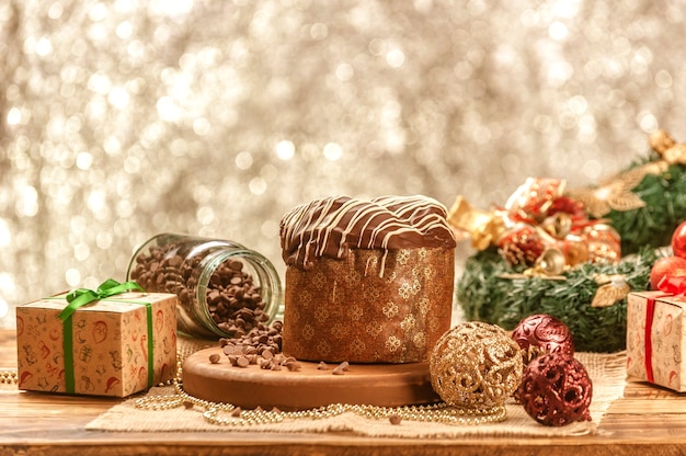Schokoladen-Panettone auf Holztisch mit Weihnachtsschmuck