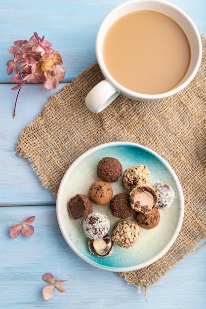 Schokoladen-Trüffel-Bonbons mit Tasse Kaffee auf einem blauen hölzernen Draufsichtabschluß oben