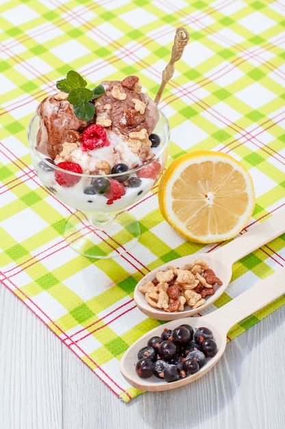 Schokoladen- und Weißeis mit Himbeer- und Johannisbeeren und Minzblättern im Glas