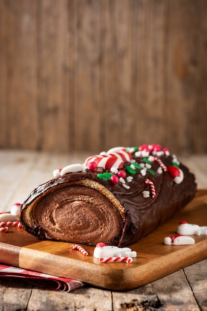 Schokoladen-Weihnachtslog-Weihnachtskuchen auf Holztisch