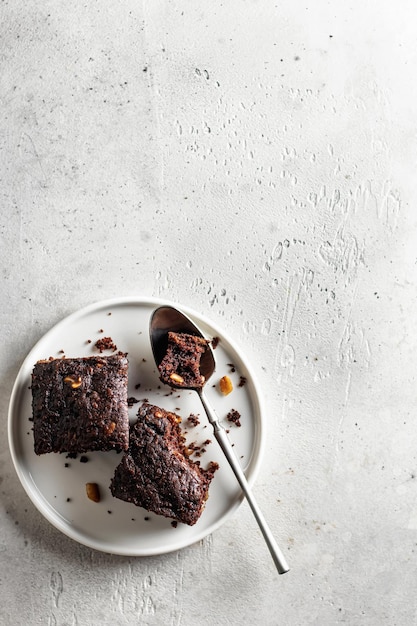 Schokoladen-Zucchini-Brownie auf einem weißen Teller auf grauem Hintergrund