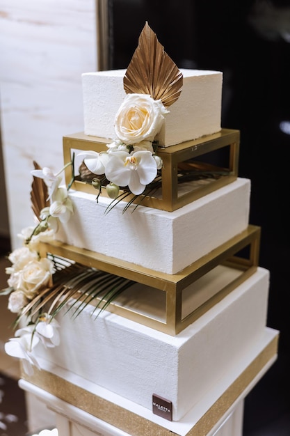 Schokoladenbar Schöner weißer Hochzeitskuchen Weißer Hochzeitkuchen mit Blumen Hochzeits kuchen im goldenen Stil