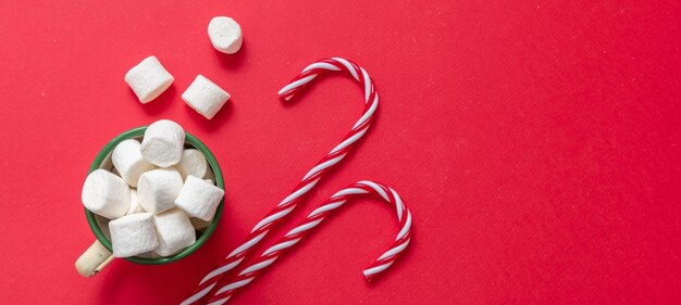 Foto schokoladenbecher mit marshmallows auf rotem hintergrund weihnachts heiß-süßes getränk