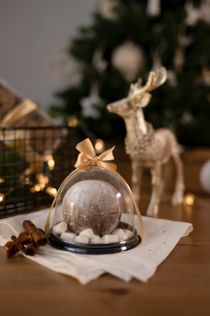 Schokoladenbombe in einem mit Satinband verzierten Behälter im weihnachtlichen Interieur