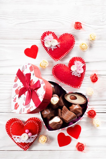 Schokoladenbox in Herzform auf weißem Holztisch-Valentinsgruß-Hintergrund