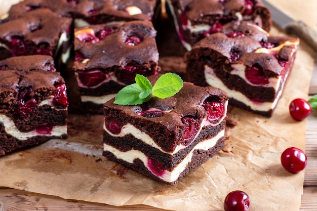 Schokoladenbrownie-Stücke, dekoriert mit Kirsche auf Holztisch