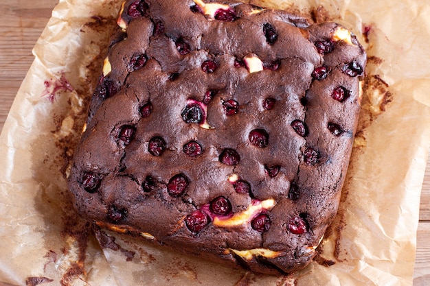 Schokoladenbrownie-Stücke, dekoriert mit Kirsche auf Holztisch