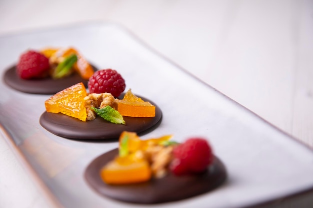 Schokoladendessert mit kandierter Orange, Himbeere und Nüssen.