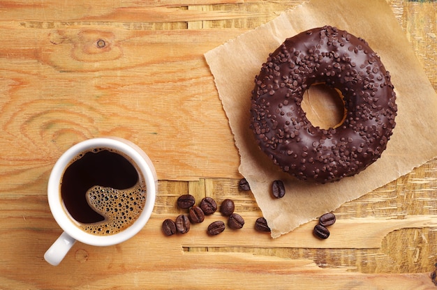 Schokoladendonut und Kaffee auf Holztisch