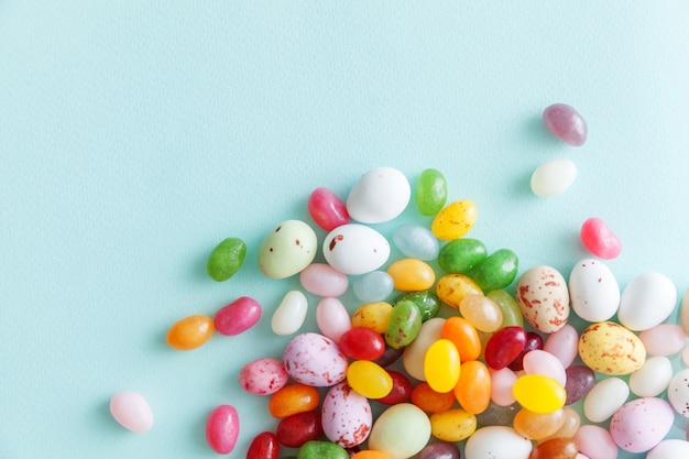 Schokoladeneier der Ostersüßigkeit und Geleebonbons lokalisiert auf trendigem pastellblauem Hintergrund