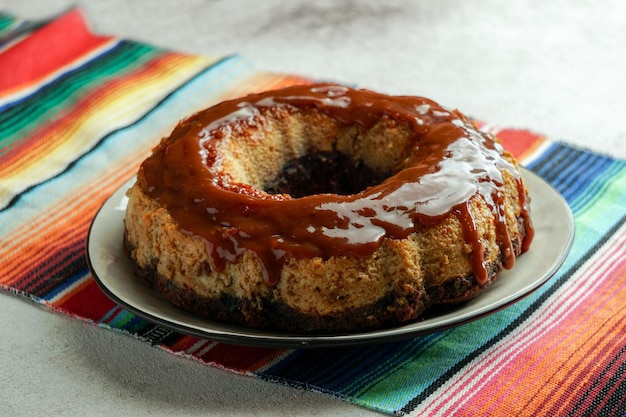 schokoladenflan, mexikanischer chocoflan, schokoladenbiskuitkuchen und karamellpuddingpudding mit einer karamellsoße auf dem dunklen holztisch