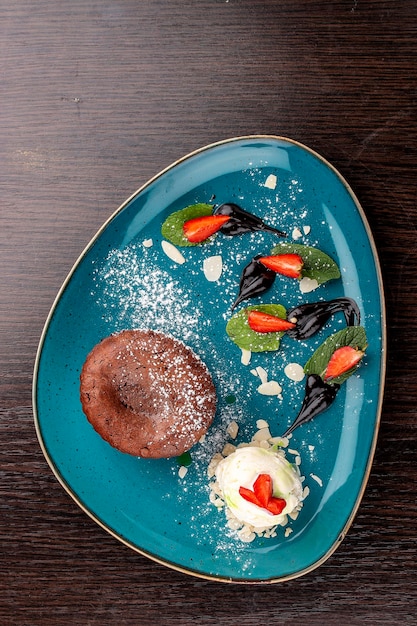 Schokoladenfondant mit Eiskugeln auf einem hölzernen Hintergrund