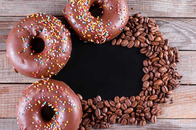 Schokoladenglutenfreie Donuts mit Kaffee auf einem Holztisch. Draufsicht mit Kopierraum