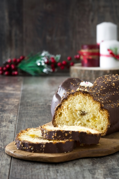 Schokoladenjulblock-Weihnachtskuchen und Weihnachtsverzierung auf hölzernem