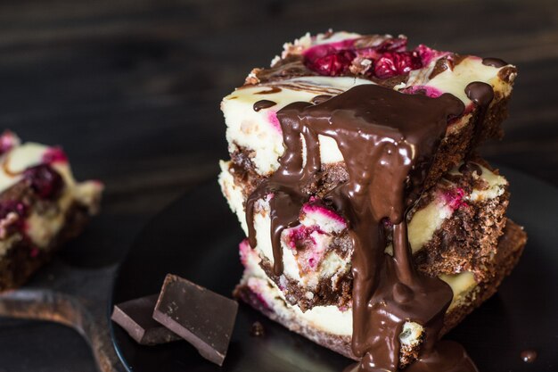 Schokoladenkäsekuchen überlagert mit Brownie und dunkler Kirsche. Schokoladen-Kirsch-Kuchen