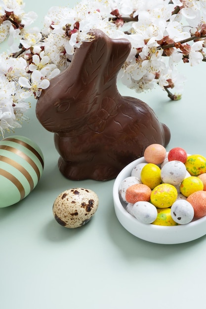 Schokoladenkaninchen und Eier symbolisieren das Osterjagdkonzept. Farbiger Hintergrund.