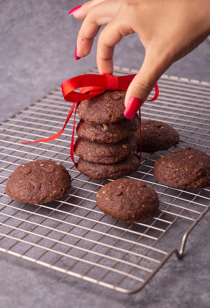 Schokoladenkekse auf einem Gestell mit rotem Weihnachtsband