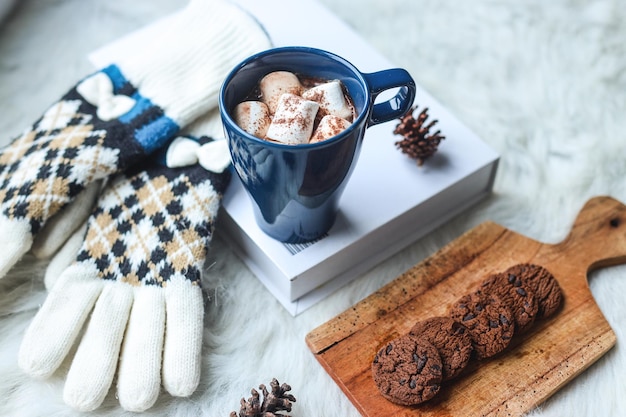 Schokoladenkekse auf Holztablett und heißes Schokoladen-Marshmallow-Getränk am Morgen