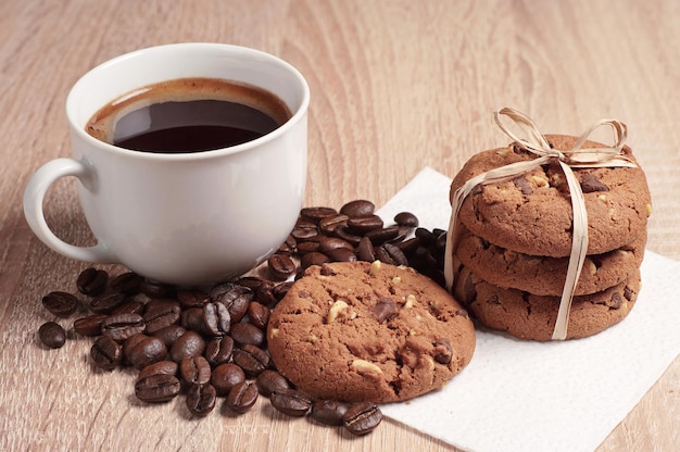 Schokoladenkekse mit Nüssen und einer Tasse heißen Kaffee auf dem Tisch