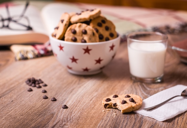 Schokoladenkekse und Milch auf Holzhintergrund