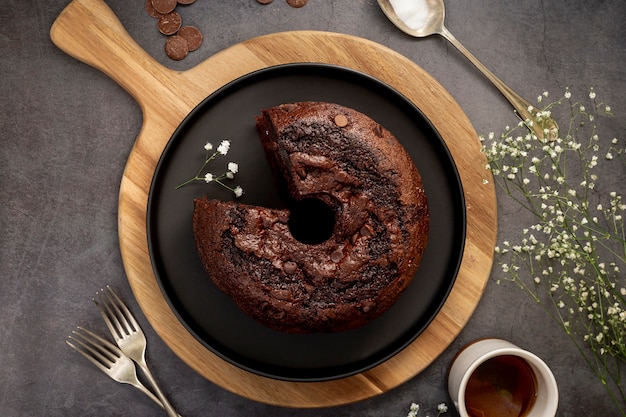 Foto schokoladenkuchen auf einem schwarzblech und einem holzbock auf einem grauen hintergrund