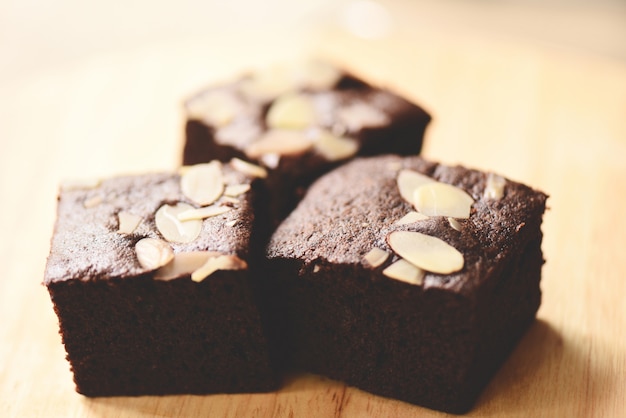 Schokoladenkuchen backen auf dem Tisch, Schokoladenkuchenscheibe mit Nuss auf hölzernem zusammen