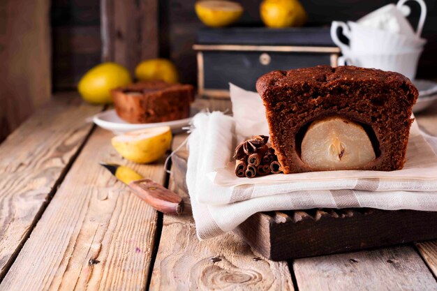 Schokoladenkuchen mit Birnen und Zimt auf alter Holzoberfläche. Selektiver Fokus.
