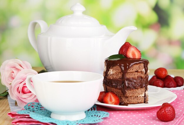 Schokoladenkuchen mit Erdbeeren auf Holztisch auf natürlichem Hintergrund