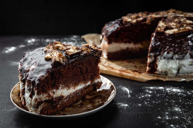 Schokoladenkuchen mit Milchmousse auf schwarzem Hintergrund