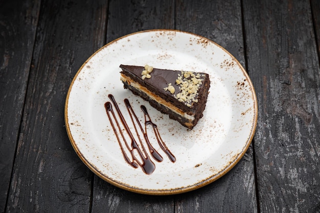 Schokoladenkuchen mit Sahne auf einem hölzernen Hintergrund