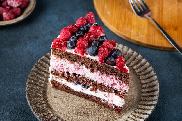 Schokoladenkuchen mit Schlagsahne und frischen Beeren Stück Himbeerkuchen Blaubeerkuchen Portion Kuchen Sommerdessert