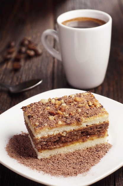 Schokoladenkuchen und heiße Tasse Kaffee auf dunklem Holztisch