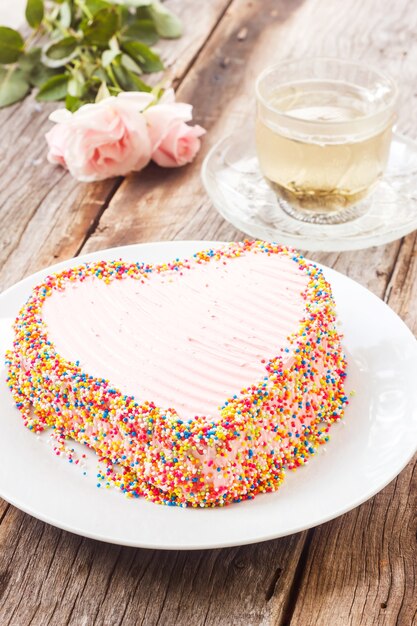 Schokoladenkuchen verzieren mit rosa Cremebutter und bunten Zuckerperlen