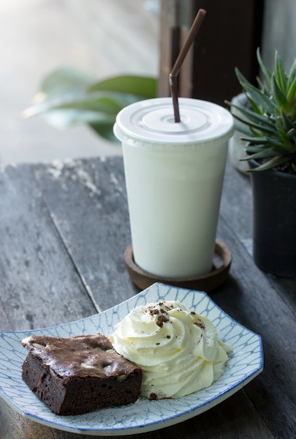 Schokoladenkuchenkuchen mit Schlagsahne und Tee auf dem Tisch