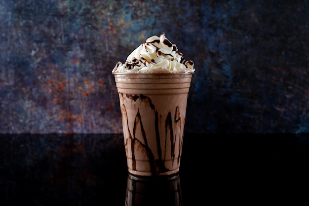 Schokoladenmilchshake serviert in einem klaren Glas auf dunklem Hintergrund Isoliertes Getränk