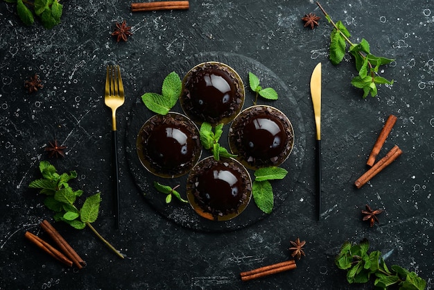 Schokoladenmousse-Dessert Oper auf einem schwarzen Teller mit Minze Draufsicht Rustikaler Stil