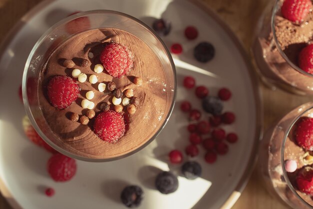 Schokoladenmousse mit Himbeeren und Erdbeeren in einem süßen Dessert aus Glas