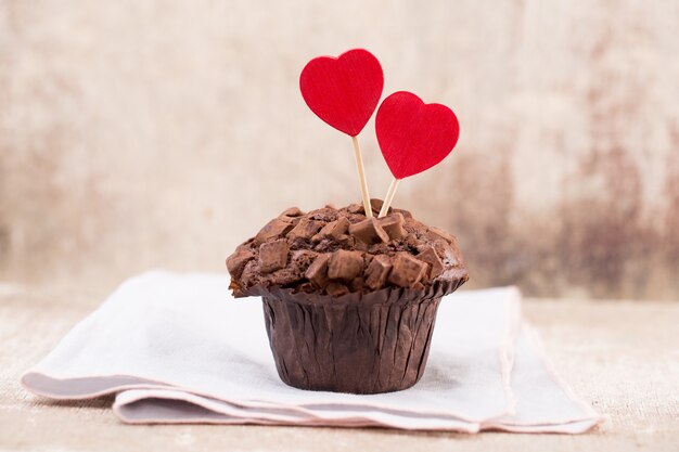 Foto schokoladenmuffins mit herzweinlesehintergrund, selektiver fokus.