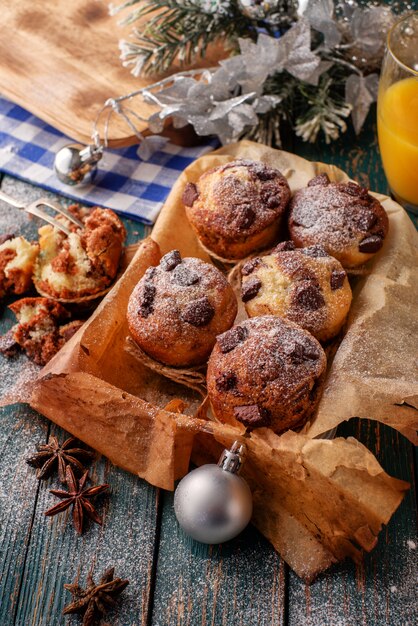 Schokoladenmuffins mit Puderzucker auf dem Holztisch, rustikale Art