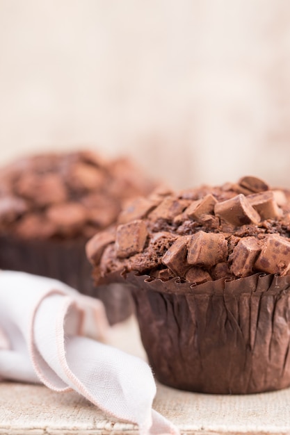 Schokoladenmuffins mit Schokolade auf rustikalem Holztisch