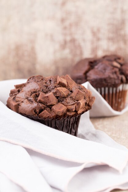 Schokoladenmuffins mit Schokolade auf rustikalem Holztisch