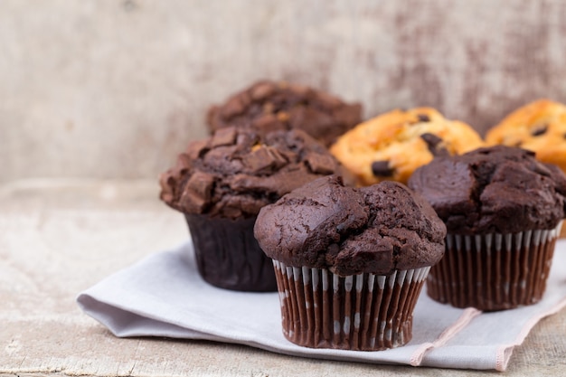 Schokoladenmuffins mit Schokoladenweinlesehintergrund, selektiver Fokus