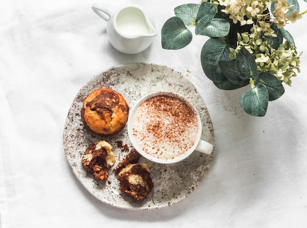 Schokoladenpaste Erdnüsse Bananenkuchen und Cappuccino auf hellem Hintergrund Draufsicht Köstliches Dessert