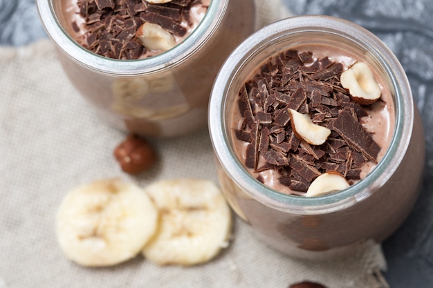 Schokoladenpudding mit Chiasamen, Bananen und Nüssen, im Glas