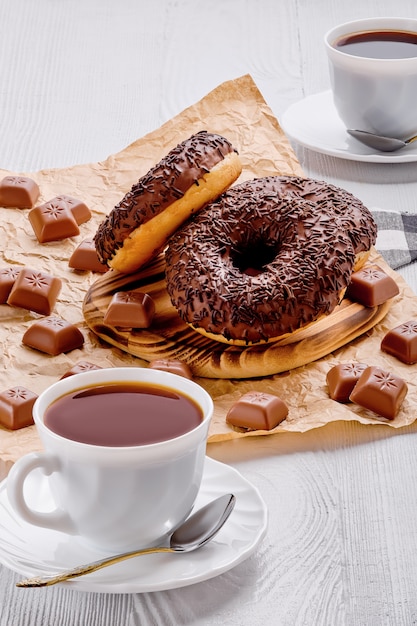 Schokoladenschaumgummiringe und -kaffee auf hellem hölzernem