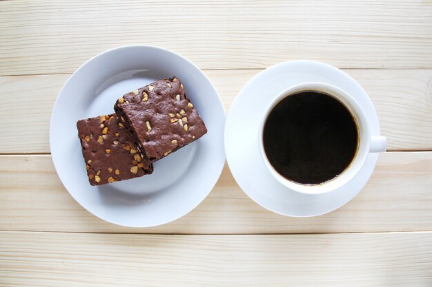 Schokoladenschokoladenkuchen und heiße schwarze Kaffeetasse auf hölzernem Hintergrund