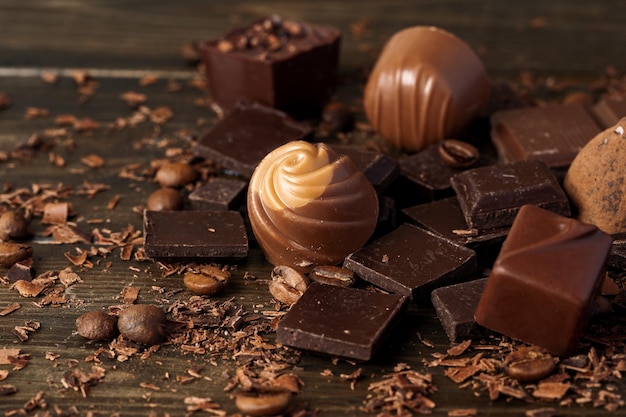 Schokoladenstücke und Süßigkeiten auf dunklem Holztisch