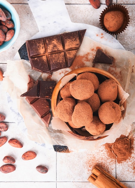 Schokoladentrüffel mit Kakaopulver in Holzschale auf altem, rissigem Fliesentisch Hintergrund Leckere süße Schokoladentrüffel Bonbons Valentinstag- und Muttertagskonzept mit Kopierbereich Ansicht von oben